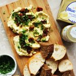 Butter board, ofwel: boter borrelplankje met peterselie, zongedroogde tomaten en 'tafelgoud'